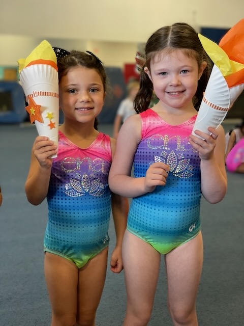 Young child practicing on the beam with a coach